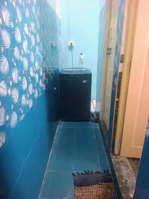 a bathroom with a blue tiled floor and a sink at Affordable home stay in Chāmrājnagar