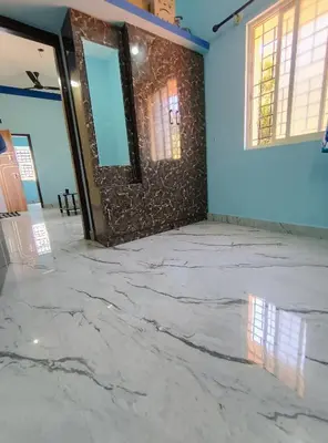 an empty room with marble floor and blue walls at Affordable home stay in Chāmrājnagar