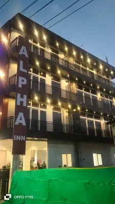 a large building with a sign in front of it at Alpha Inn in Vālpārai
