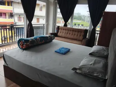 a large bed in a room with a couch at Alpha Inn in Vālpārai
