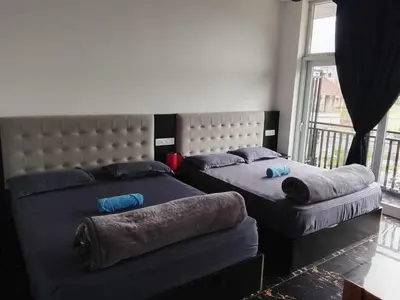 a bedroom with two beds and a large window at Alpha Inn in Vālpārai