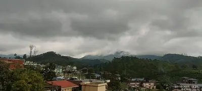 a view of a city with mountains in the background at Alpha Inn in Vālpārai