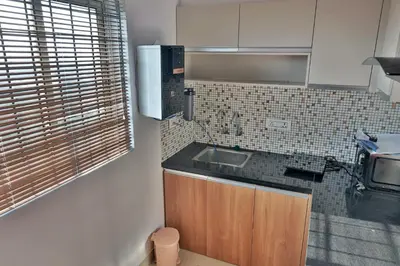 a kitchen with a sink and a microwave at Vaiga Heavens , 1 BHK Apartment in Guruvāyūr