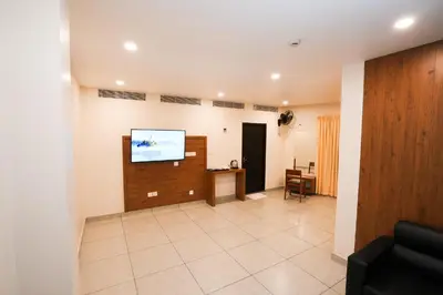 a living room with a flat screen tv on a wall at IGNIVA Airport Hotel in Calicut