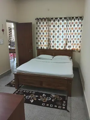 a bedroom with a bed in a room with a window at Formula 1 Premium Villa in Mysore
