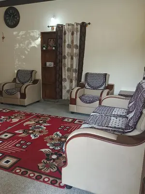 a living room with two chairs and a rug at Formula 1 Premium Villa in Mysore