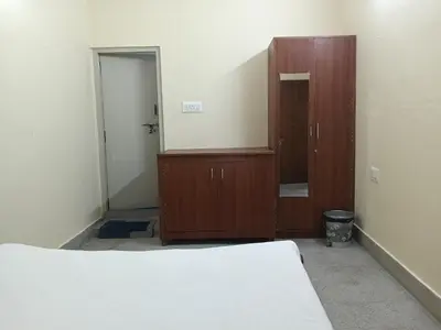 a bedroom with a bed and a dresser and a mirror at Formula 1 Premium Villa in Mysore