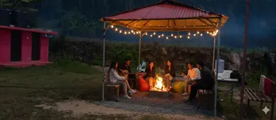 a group of people sitting around a fire under a tent at Moonhills Cabins in Vattavada
