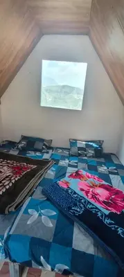 a bedroom with a bed with a blue andkered floor at Moonhills Cabins in Vattavada