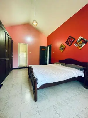 a bedroom with red walls and a large bed at Grays club guest House in Coonoor