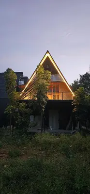 a house sitting on top of a lush green field at Ambience Retreat in Malavalli