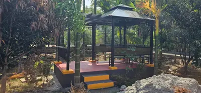 a gazebo in a garden with a tree at Ambience Retreat in Malavalli