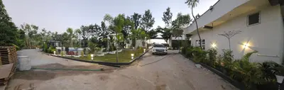 a truck parked in a driveway next to a building at Ambience Retreat in Malavalli