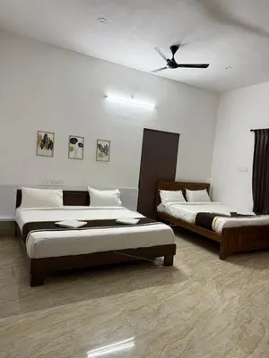 a bedroom with two beds and a ceiling fan at Prysm Homestay - Kotagiri in Kotagiri