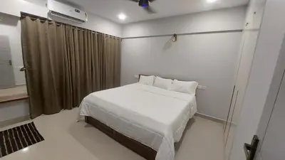 a bedroom with a white bed and a window at Lavender airport suite in Angamali