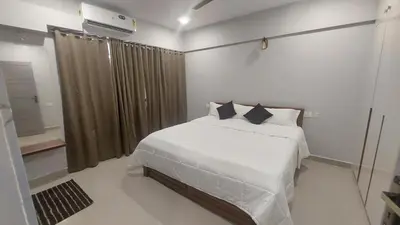 a bedroom with a bed with white sheets and pillows at Lavender airport suite in Angamali