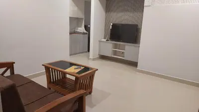 a living room with a couch and a television at Lavender airport suite in Angamali