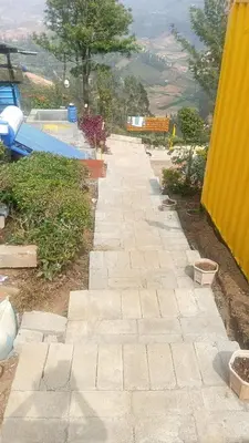 a stone walkway next to a swimming pool at Janardan Campsite Ooty in Ooty