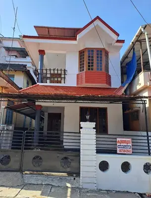 a house with a sign in front of it at Kunjoose Ladies Hostel in Trichūr