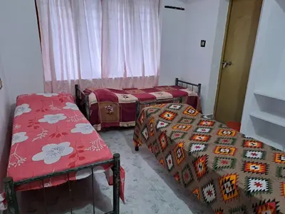 a room with three beds in a room at Kunjoose Ladies Hostel in Trichūr