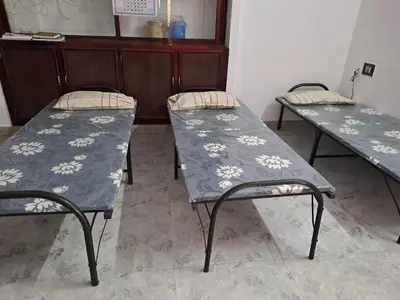 two empty beds in a room with at Kunjoose Ladies Hostel in Trichūr