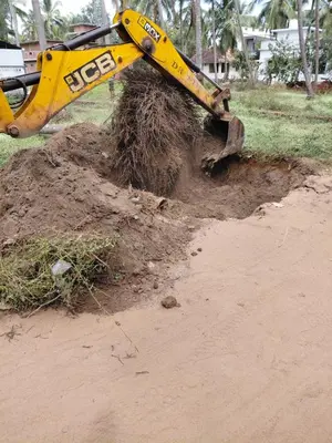 a yellow bulldozer is stuck in a pile of dirt at Paarpidam in Tānūr