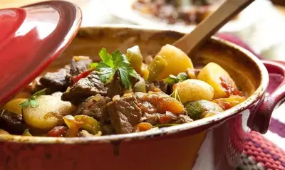 a bowl of food with meat and vegetables at Paarpidam in Tānūr