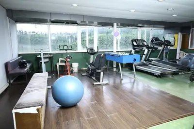 a fitness room with a gym with a large blue ball at Valparai home villas in Vālpārai