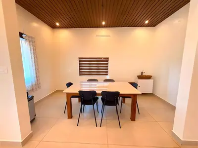 a dining room with a table and chairs at Evara Stays Coorg in Kushālnagar
