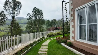 a garden with a white fence and a walkway at Amariyah House -Luxury Villa in Coonoor in Coonoor
