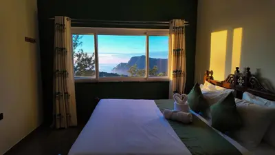 a bedroom with a large bed with a large window at Amariyah House -Luxury Villa in Coonoor in Coonoor