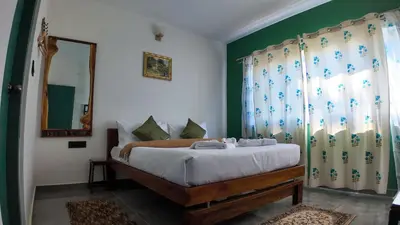 a bedroom with a bed with green walls and a mirror at Amariyah House -Luxury Villa in Coonoor in Coonoor