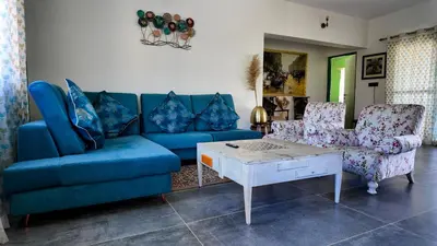 a living room with a blue couch and two chairs at Amariyah House -Luxury Villa in Coonoor in Coonoor