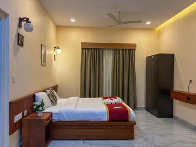 a bedroom with a bed and a window at Maple grove villa resort in Panamaram