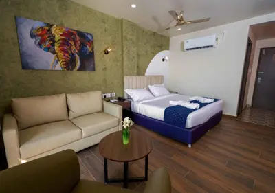 a hotel room with a bed and a couch at River Bay Athirappilly in Athirappilly
