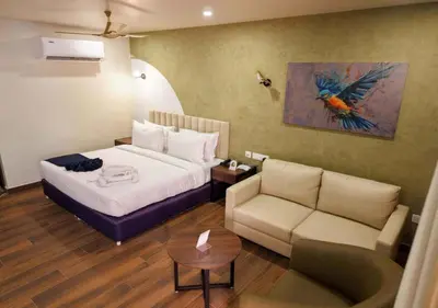 a hotel room with a bed and a couch at River Bay Athirappilly in Athirappilly