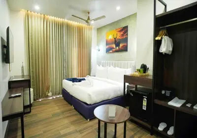a hotel room with a large bed and a table at River Bay Athirappilly in Athirappilly