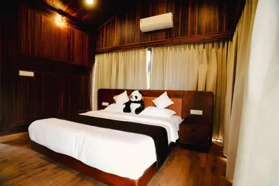 a bedroom with a bed with a panda bear on it at Wood Panda Luxury Resort Wayanad in Meppādi