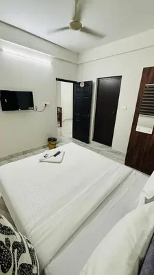 a large white bed in a room with a fan at MIRACLE inn NEAR AL-AMEEN COLLEGE in Alwaye