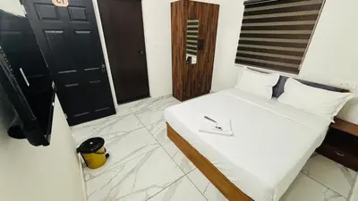 a bedroom with a bed with white sheets at MIRACLE inn NEAR AL-AMEEN COLLEGE in Alwaye