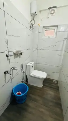 a bathroom with a toilet and a blue bucket at MIRACLE inn NEAR AL-AMEEN COLLEGE in Alwaye