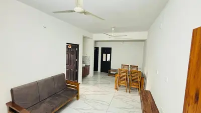 a living room with a couch and a table and chairs at MIRACLE inn NEAR AL-AMEEN COLLEGE in Alwaye