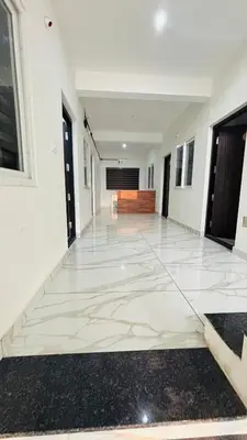 a hallway of a building with a white tile floor at MIRACLE inn NEAR AL-AMEEN COLLEGE in Alwaye