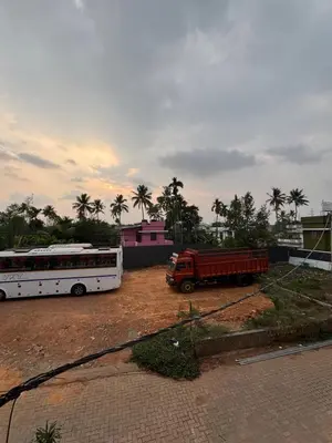 two buses and a truck parked in a parking lot at MIRACLE inn NEAR AL-AMEEN COLLEGE in Alwaye