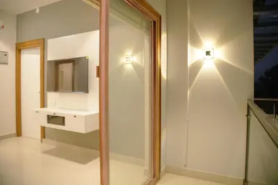a bathroom with a white sink and a mirror at Gentur Enclave in Mananthavady