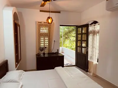 a bedroom with a bed and a window at Mathangi - A Countryside Homestay for Family and Solo Travelers in Kozhikode