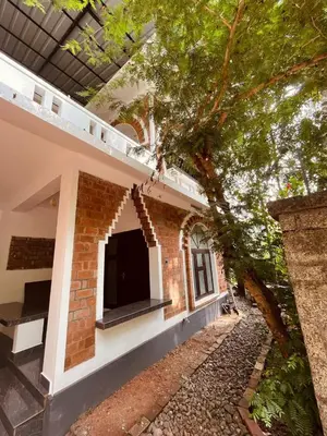 a brick building with a tv on top of it at Mathangi - A Countryside Homestay for Family and Solo Travelers in Kozhikode