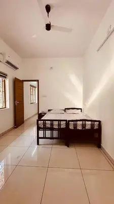 a room with a bed in the middle of a room at Snehanilayam-1 in Trichūr