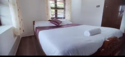 a small bedroom with two beds and a window at Blue chill villa in Madikeri
