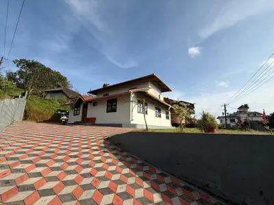 a house with a brick driveway in front of it at Blue chill villa in Madikeri